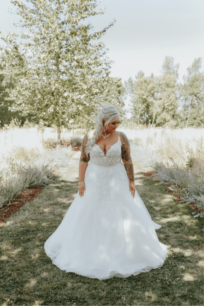 woman in white spaghetti-strapped wedding gown standing in a park