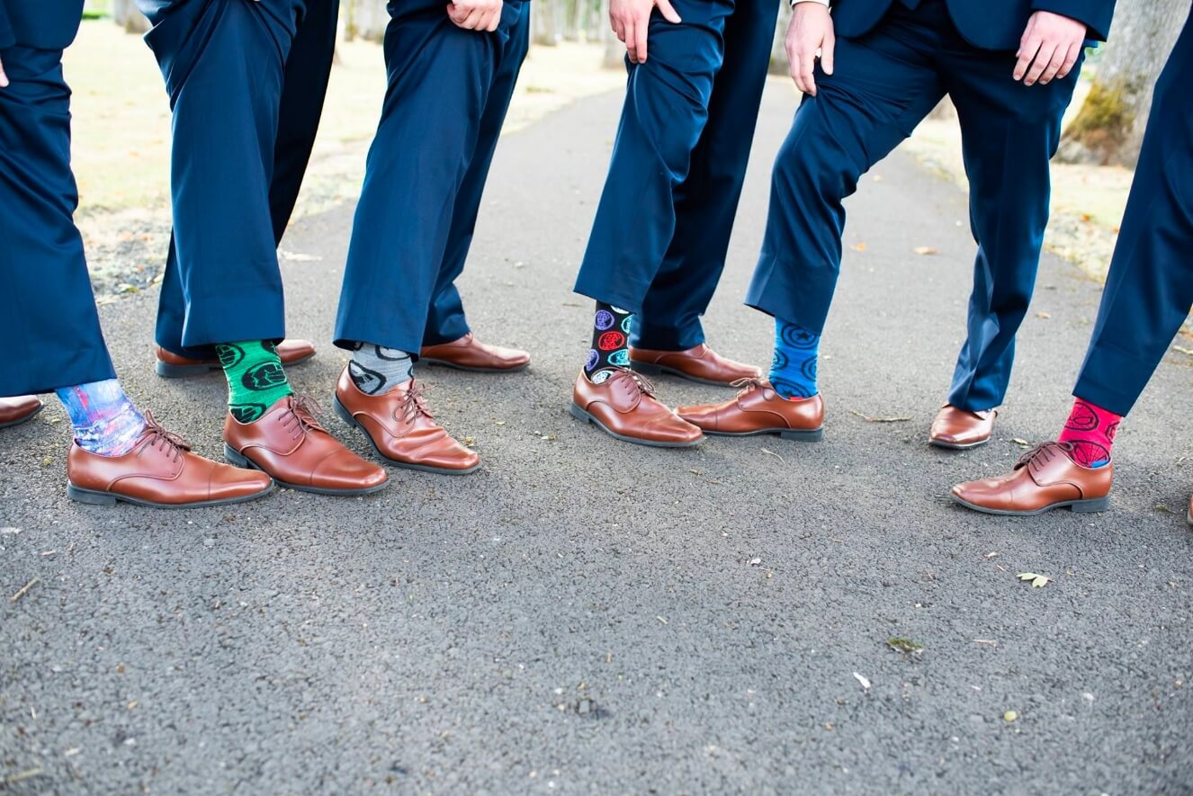 groom and groomsmen raising pants to show wacky socks